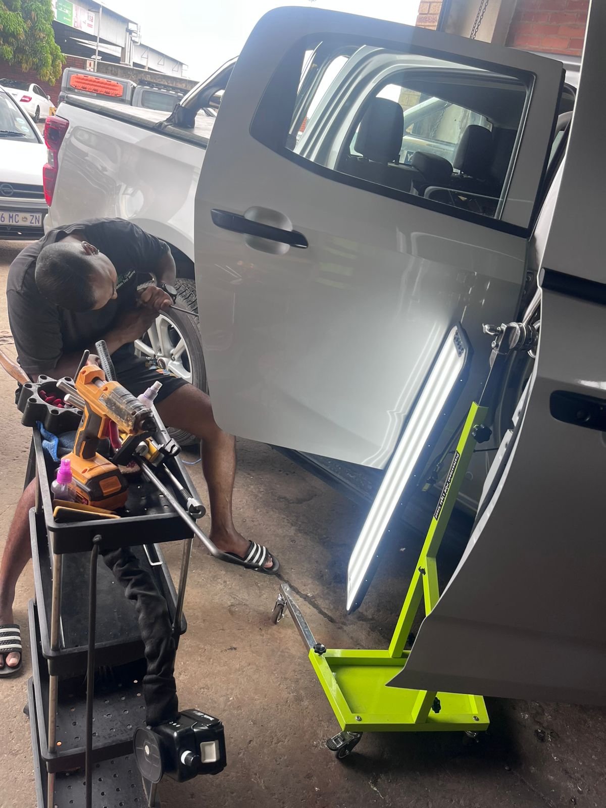 Wesley working on vehicle door panel with professional PDR LED light board